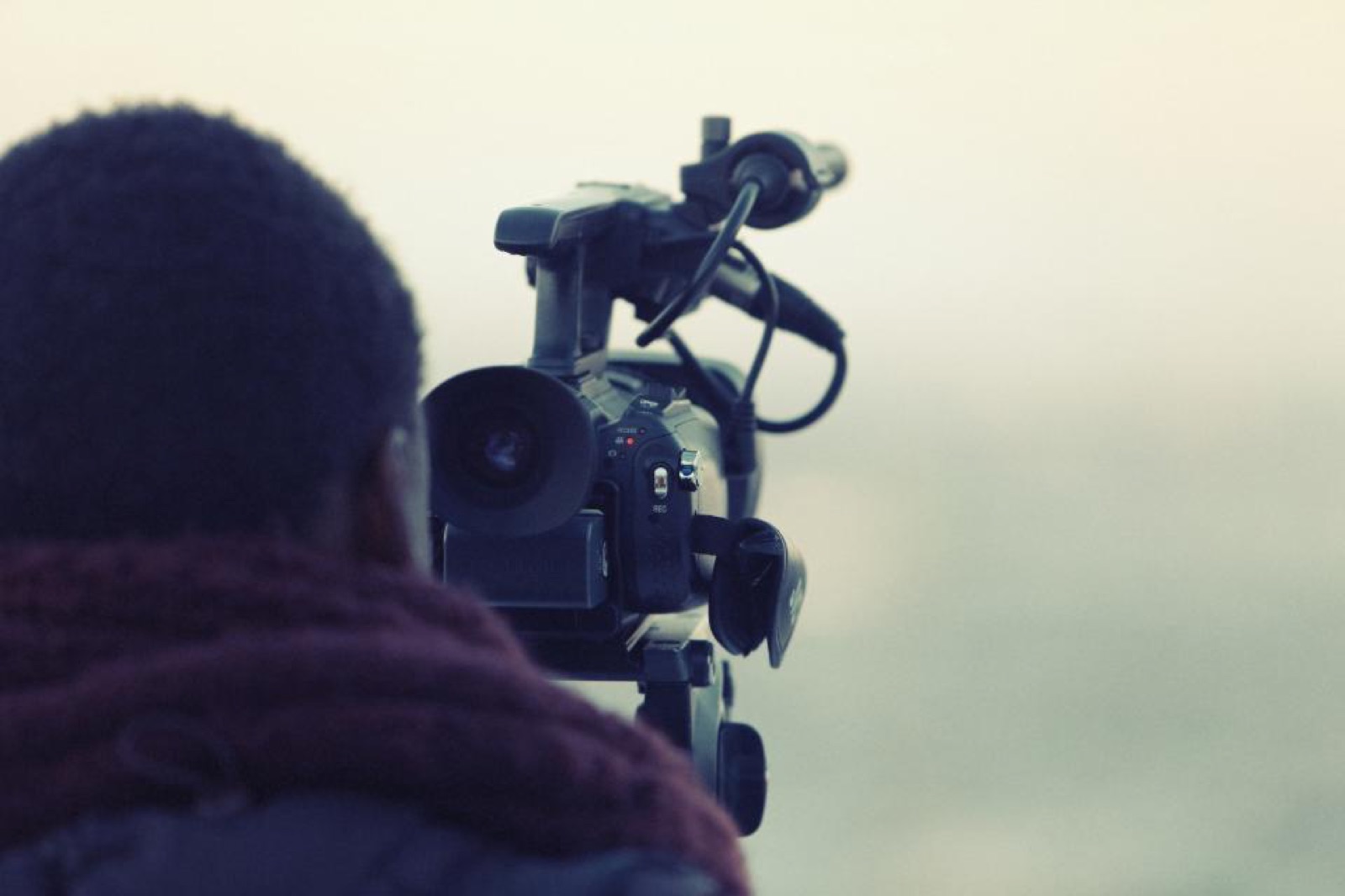 Videographer behind a professional video camera